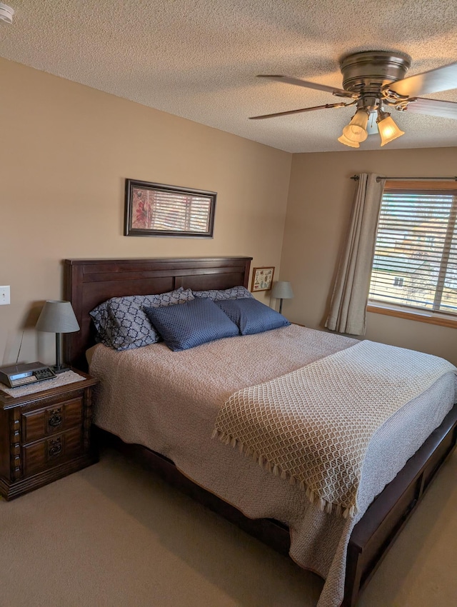 carpeted bedroom with a textured ceiling and a ceiling fan