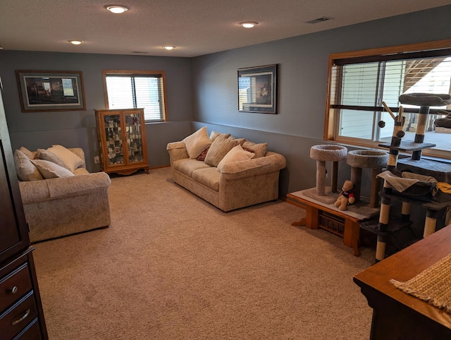 living area with visible vents, recessed lighting, a textured ceiling, and carpet