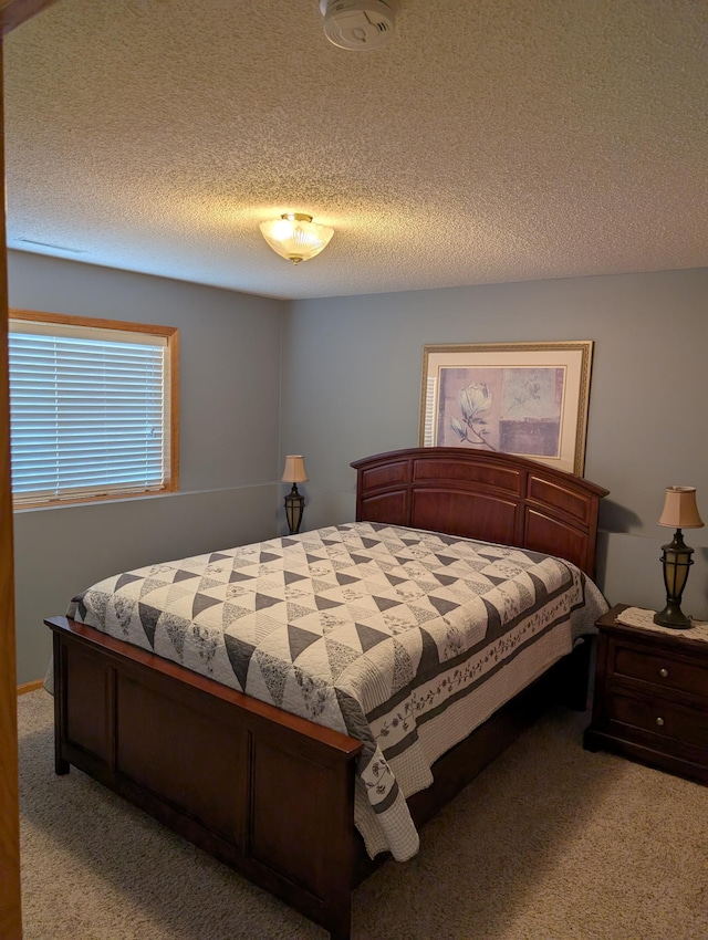 bedroom with light carpet and a textured ceiling