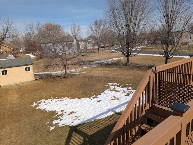 snowy yard with a storage unit and an outdoor structure