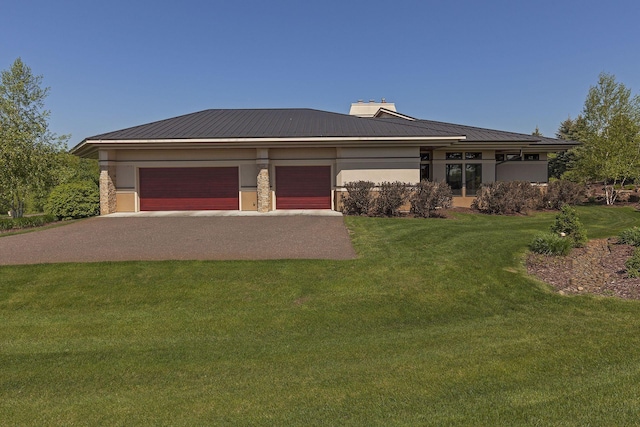 prairie-style house with stucco siding, a front lawn, a garage, and metal roof