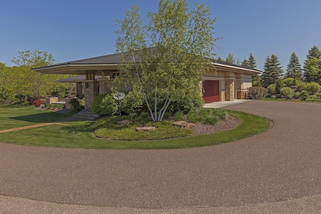 view of front of property with a front yard, an attached garage, and driveway