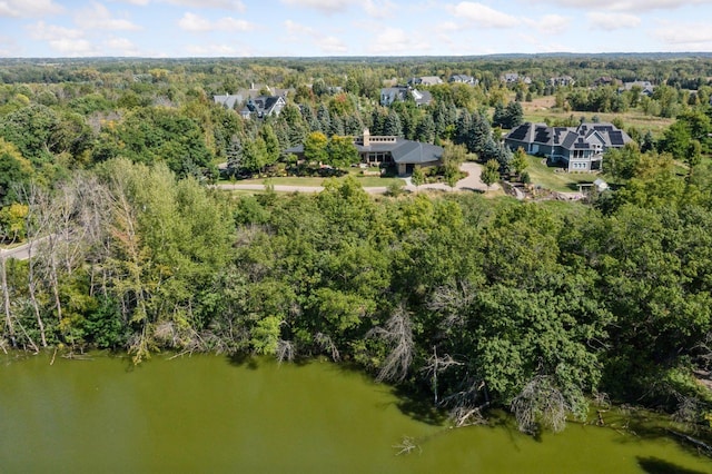 birds eye view of property featuring a wooded view and a water view