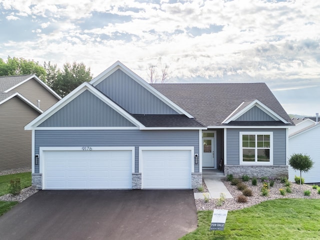 9176 62nd St S, Cottage Grove, MN 55016 - craftsman house with stone siding, a shingled roof, driveway, and an attached garage