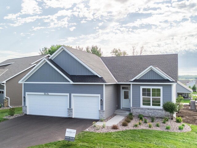 9176 62nd St S, Cottage Grove, MN 55016 - view of front of home with a garage, stone siding, driveway, and a shingled roof