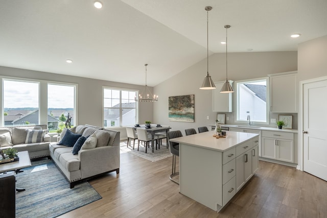 9176 62nd St S, Cottage Grove, MN 55016 - kitchen featuring vaulted ceiling, a center island, light countertops, a chandelier, and white cabinets