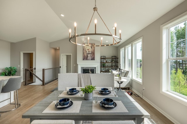 9176 62nd St S, Cottage Grove, MN 55016 - dining room featuring a chandelier, light wood finished floors, lofted ceiling, and a fireplace