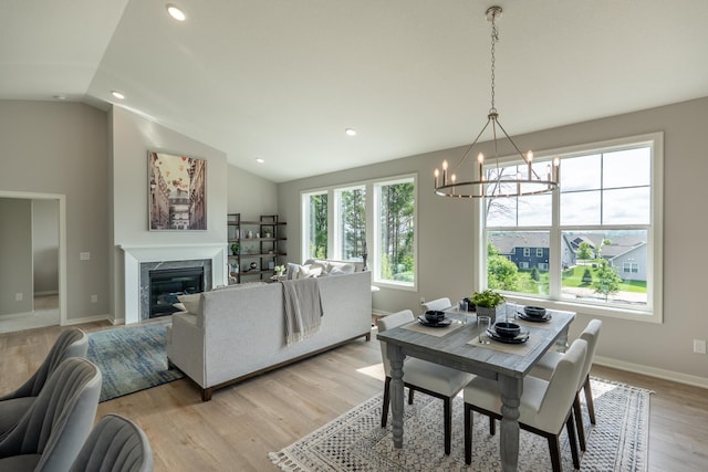 9176 62nd St S, Cottage Grove, MN 55016 - dining space featuring vaulted ceiling, a chandelier, light wood-style flooring, recessed lighting, and a premium fireplace