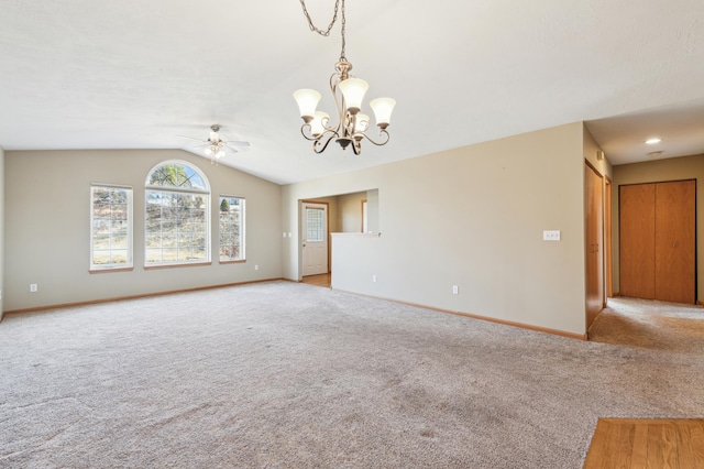 unfurnished room featuring vaulted ceiling, ceiling fan with notable chandelier, baseboards, and light carpet