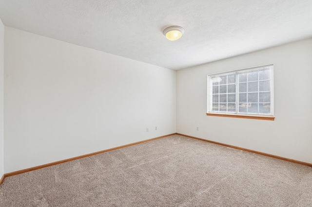 carpeted spare room with baseboards