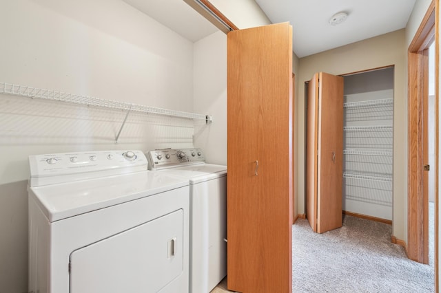 laundry area featuring laundry area, washer and dryer, light colored carpet, and baseboards