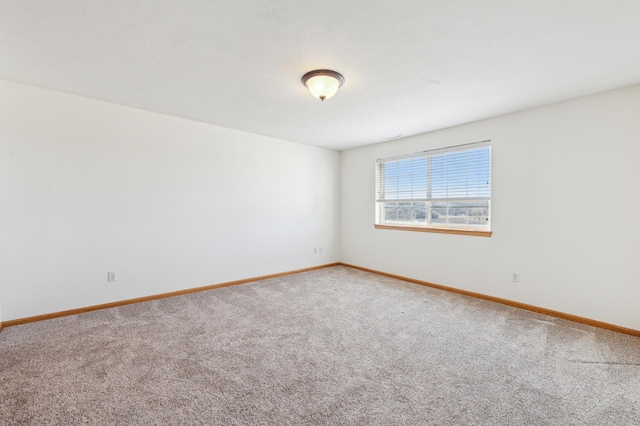 spare room featuring baseboards and carpet floors