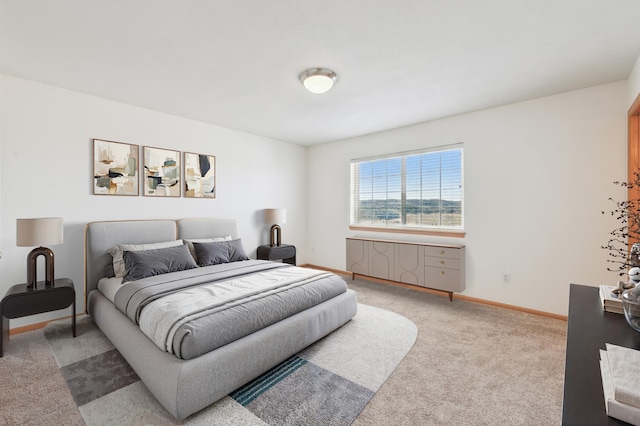 bedroom featuring baseboards and light carpet