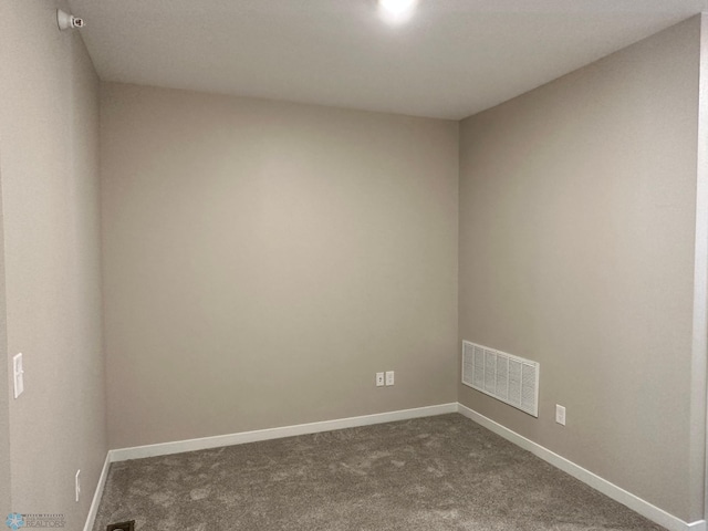 empty room featuring baseboards, visible vents, and dark colored carpet