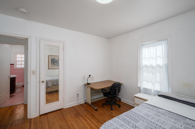 bedroom with baseboards, multiple windows, and hardwood / wood-style flooring