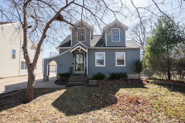 view of front of home featuring a shingled roof and fence