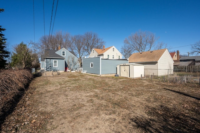 view of yard with an outdoor structure, fence, and a shed