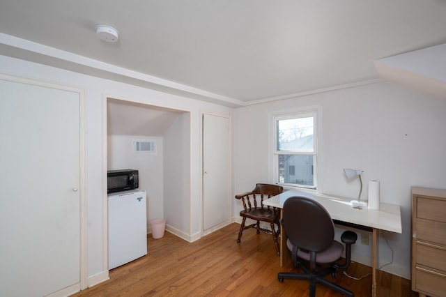 office space featuring vaulted ceiling, visible vents, and light wood-type flooring