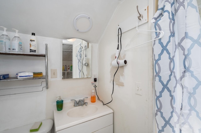 bathroom with backsplash, tile walls, vanity, and toilet