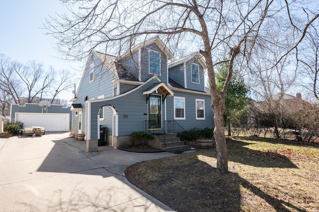 view of front of home with concrete driveway and an outdoor structure