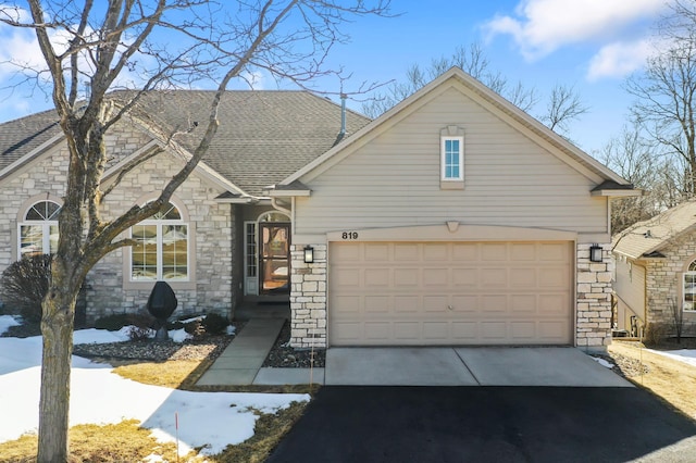 view of front of house featuring concrete driveway, a garage, and roof with shingles