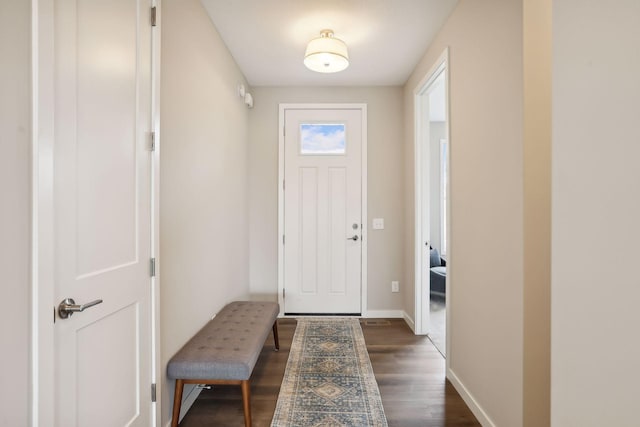 doorway featuring dark wood finished floors and baseboards