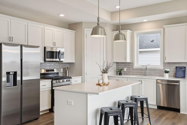 9184 62nd St S, Cottage Grove, MN 55016 - kitchen featuring appliances with stainless steel finishes, backsplash, white cabinets, a center island, and light countertops