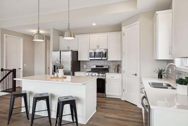 9184 62nd St S, Cottage Grove, MN 55016 - kitchen with stainless steel appliances, a kitchen breakfast bar, decorative backsplash, white cabinets, and recessed lighting