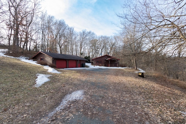 snow covered property featuring a garage and driveway