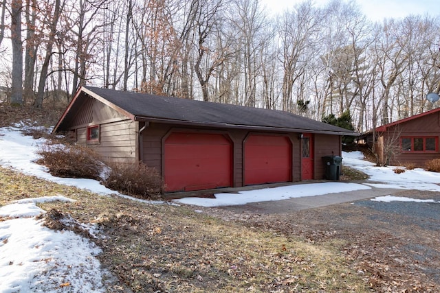 snow covered garage featuring a detached garage