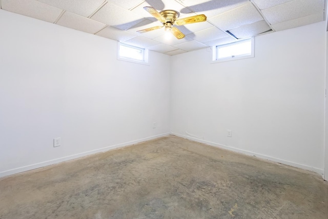 basement featuring a drop ceiling and baseboards