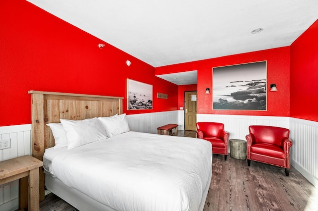 bedroom with wood finished floors and wainscoting