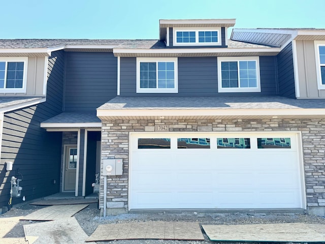 view of front of home featuring a garage and stone siding