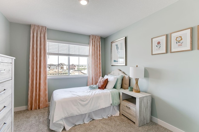bedroom with baseboards and light carpet
