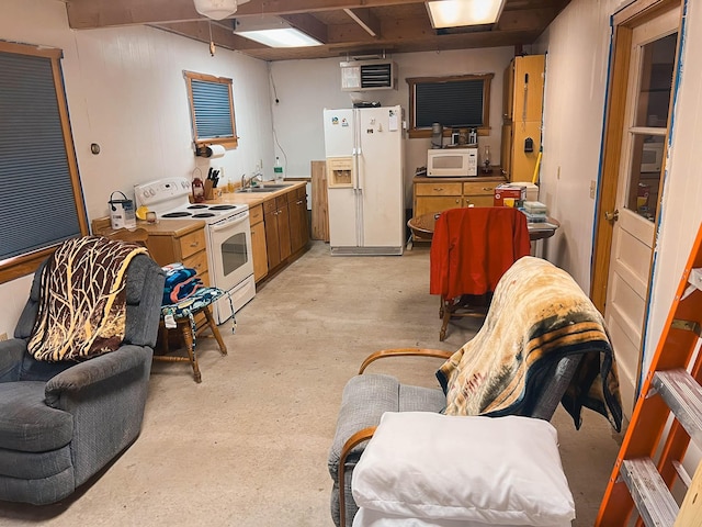 kitchen featuring white appliances, concrete flooring, and a sink