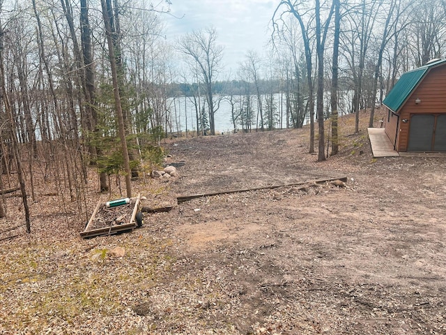 view of yard featuring a garage and dirt driveway