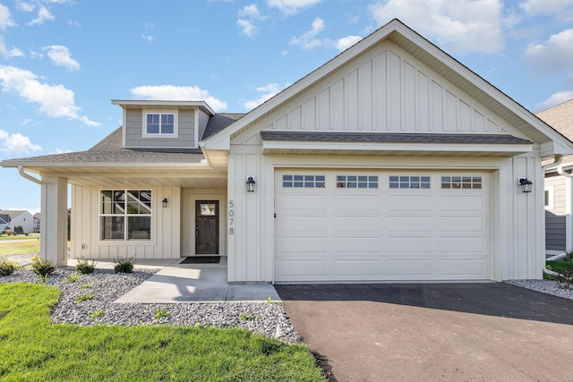 view of front facade featuring aphalt driveway, a garage, board and batten siding, and a shingled roof