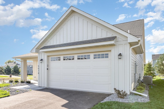 garage featuring central air condition unit and driveway