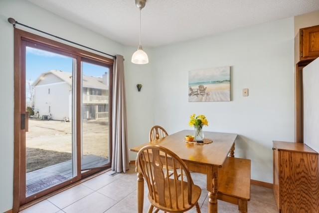 dining space featuring light tile patterned flooring and baseboards