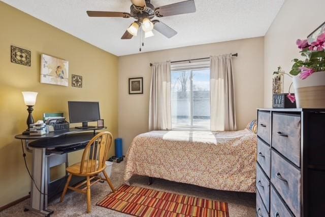 bedroom with ceiling fan and dark colored carpet