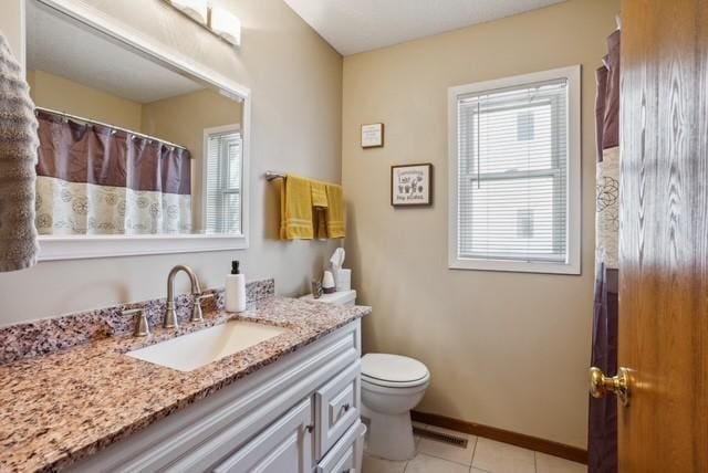 bathroom with vanity, visible vents, baseboards, tile patterned flooring, and toilet