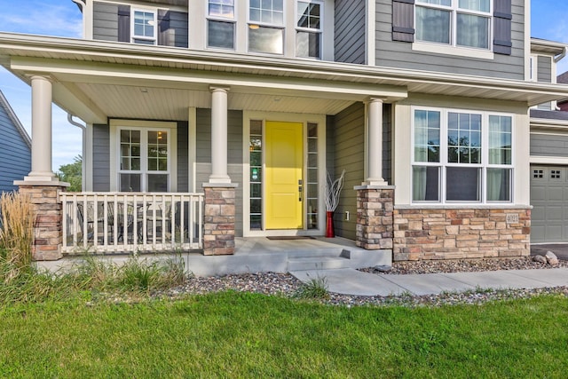 doorway to property with stone siding and covered porch