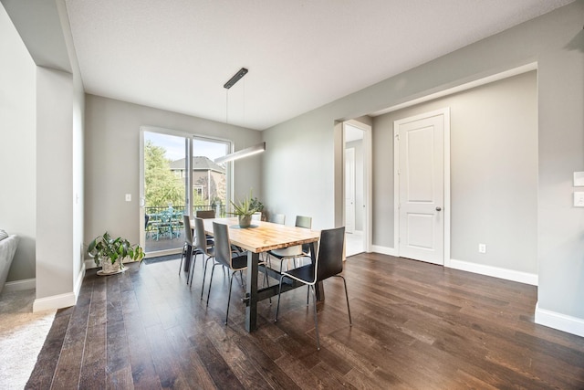 dining space with baseboards and dark wood-style floors