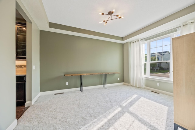 interior space with visible vents, baseboards, a notable chandelier, and carpet flooring