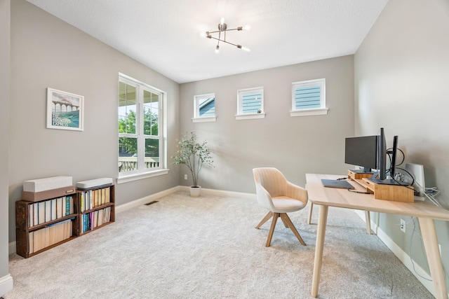 office space featuring a notable chandelier, visible vents, baseboards, and carpet floors