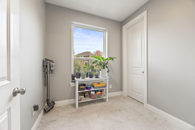 interior space featuring marble finish floor and baseboards