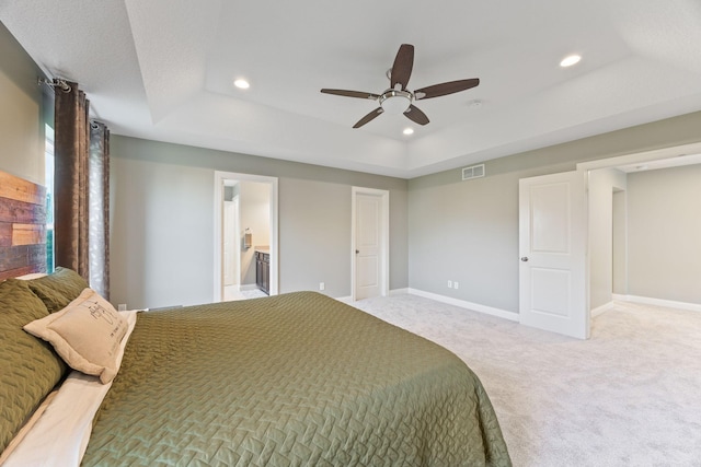 carpeted bedroom featuring visible vents, baseboards, a tray ceiling, recessed lighting, and a ceiling fan