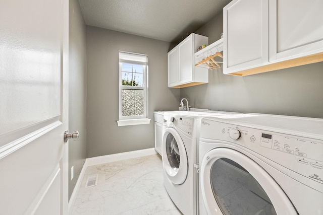 clothes washing area with visible vents, marble finish floor, cabinet space, baseboards, and washing machine and clothes dryer