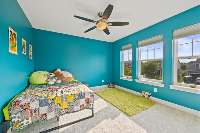 carpeted bedroom with baseboards and ceiling fan