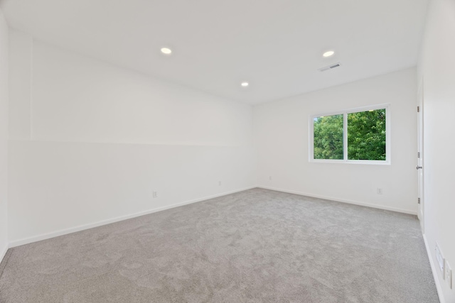 empty room featuring carpet, recessed lighting, visible vents, and baseboards